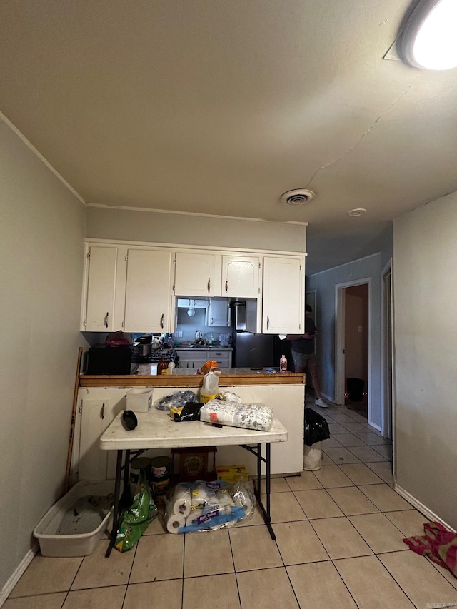 kitchen featuring white cabinetry, visible vents, baseboards, and light tile patterned flooring