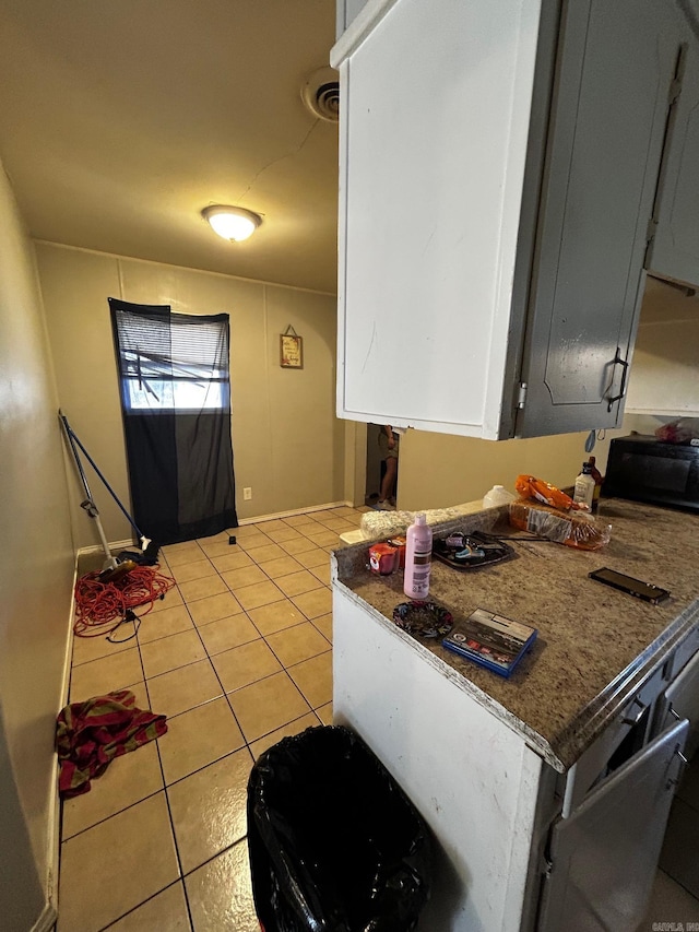 kitchen with light tile patterned floors, visible vents, and white cabinets