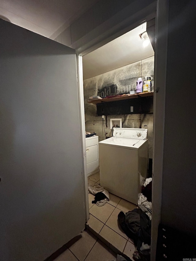 washroom featuring laundry area, washer and clothes dryer, and light tile patterned floors