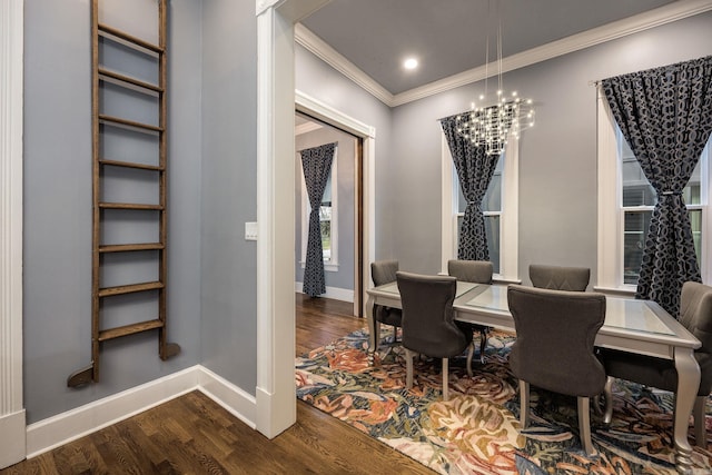 dining room featuring dark wood-style floors, a notable chandelier, ornamental molding, and baseboards