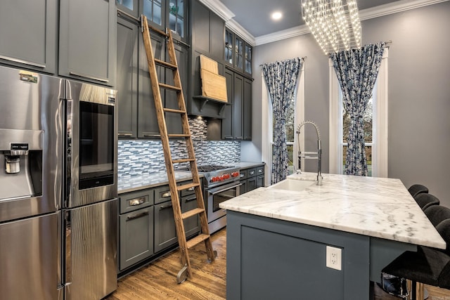 kitchen featuring a breakfast bar, crown molding, stainless steel appliances, decorative backsplash, and a sink