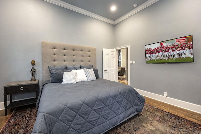 bedroom with crown molding, wood finished floors, and baseboards