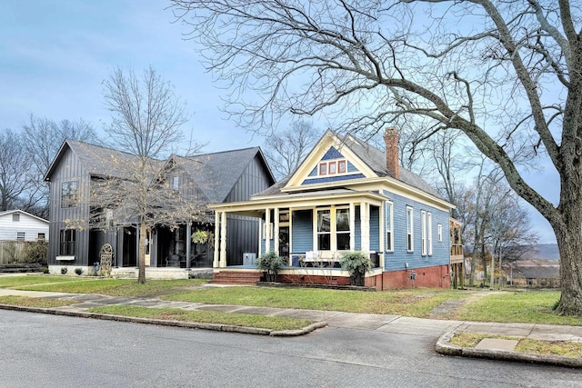 view of front of house featuring a porch, crawl space, a chimney, and a front lawn