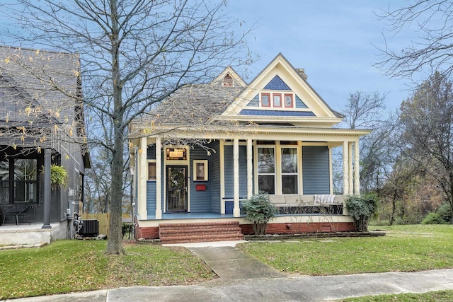 view of front facade featuring a porch, a front lawn, and central air condition unit