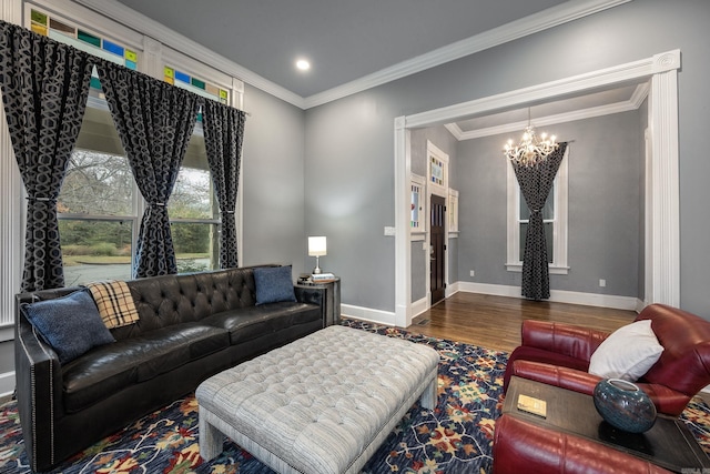 living room with baseboards, ornamental molding, wood finished floors, and a notable chandelier