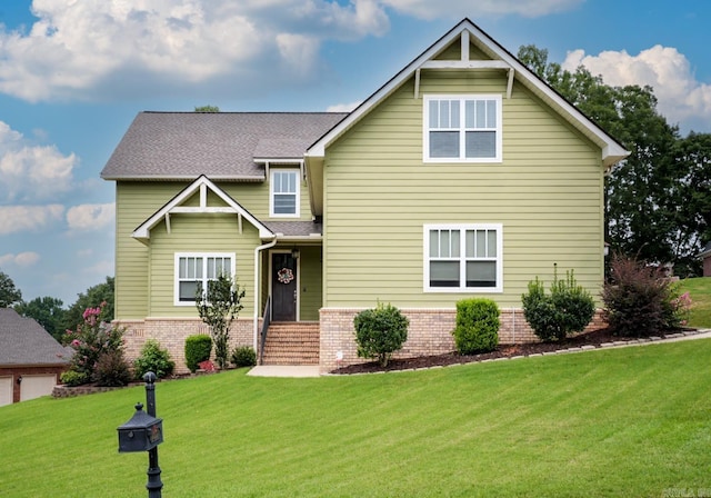 craftsman inspired home with a shingled roof, a garage, brick siding, and a front lawn