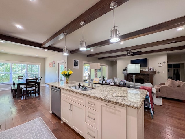 kitchen featuring dark wood finished floors, open floor plan, white cabinetry, a sink, and dishwasher