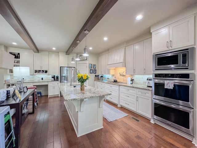 kitchen featuring dark wood-style flooring, custom exhaust hood, stainless steel appliances, white cabinets, and beamed ceiling