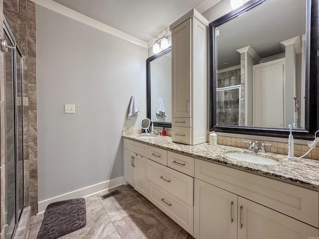 full bath with a sink, visible vents, baseboards, double vanity, and a stall shower