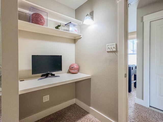 home office with baseboards, built in desk, and a textured wall