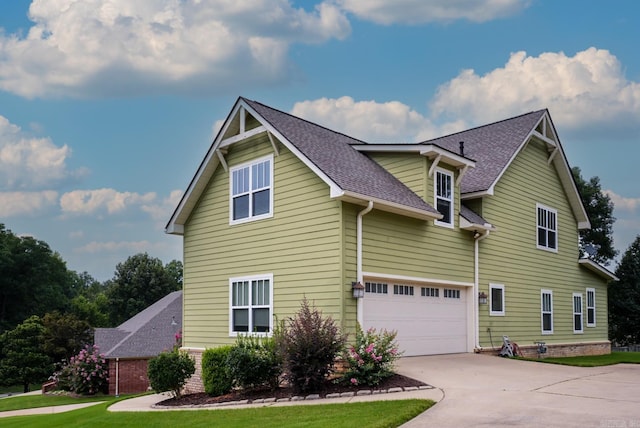 view of front of home featuring roof with shingles, driveway, and an attached garage