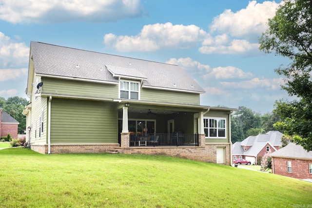 back of property with a yard and a shingled roof