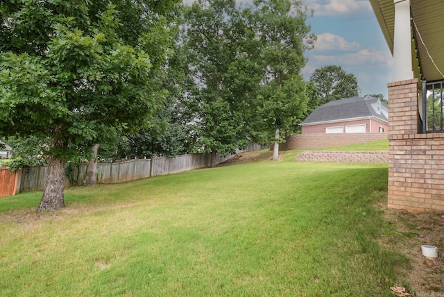 view of yard with a garage and a fenced backyard