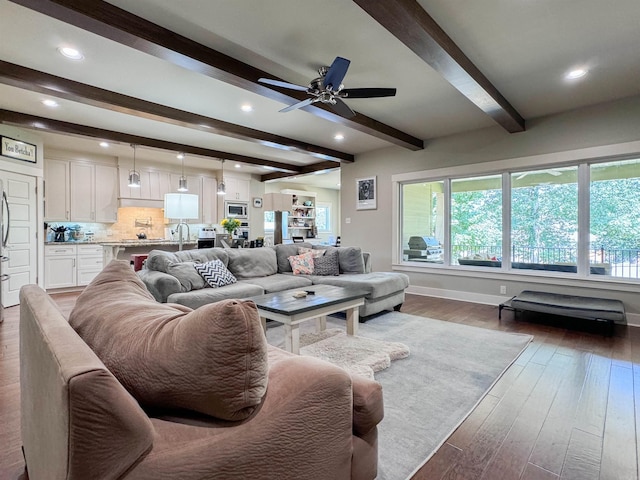 living room with ceiling fan, recessed lighting, baseboards, dark wood-style floors, and beamed ceiling