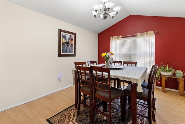 dining room featuring lofted ceiling, light wood finished floors, baseboards, and a notable chandelier