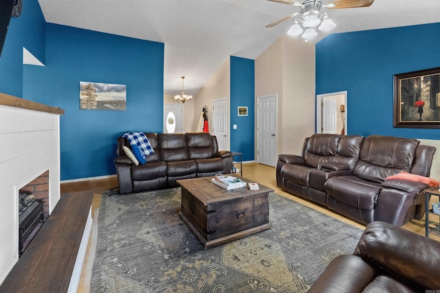 living room featuring a fireplace, wood finished floors, high vaulted ceiling, baseboards, and ceiling fan with notable chandelier