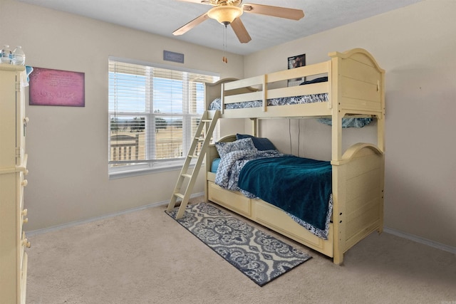 carpeted bedroom with a ceiling fan and baseboards