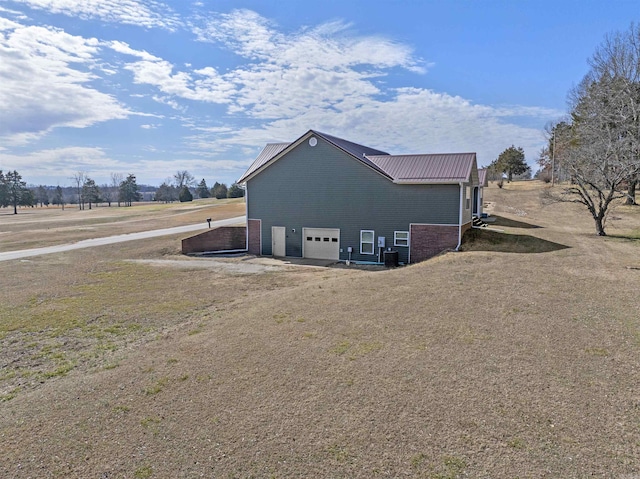 view of outbuilding featuring a garage, driveway, and central air condition unit