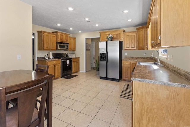 kitchen featuring light tile patterned floors, appliances with stainless steel finishes, a sink, and recessed lighting