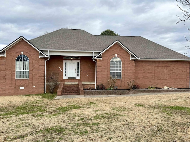 single story home with brick siding, crawl space, a shingled roof, and a front yard