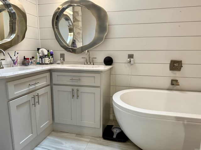 full bath with a sink, a bathing tub, and double vanity