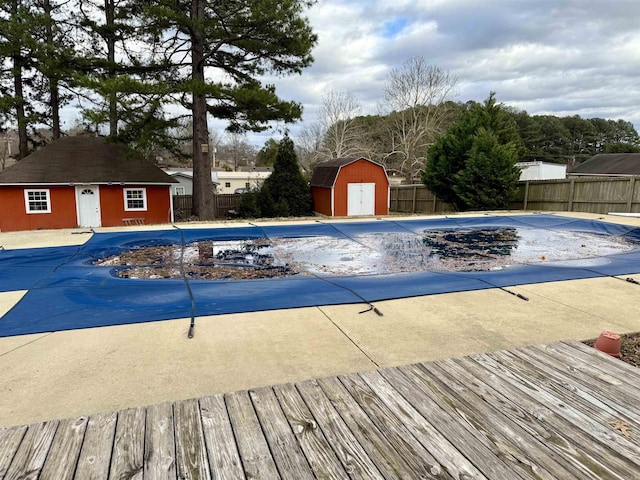 view of swimming pool with a fenced in pool, an outbuilding, a fenced backyard, and a storage shed