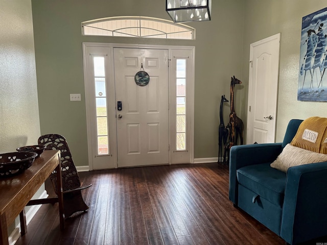 foyer entrance featuring baseboards and dark wood finished floors