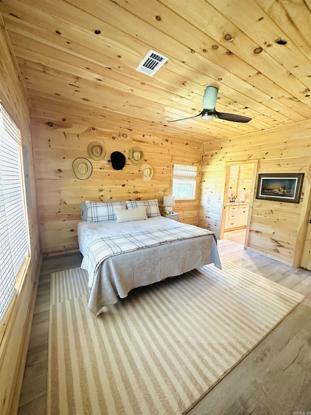 bedroom featuring wooden ceiling, visible vents, and wooden walls