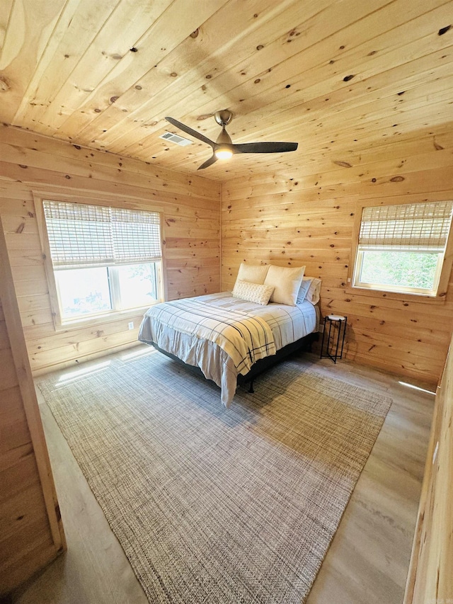 bedroom featuring wood ceiling, multiple windows, wooden walls, and wood finished floors