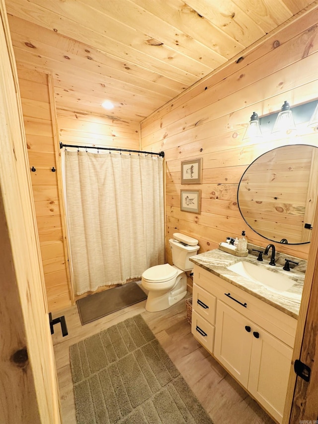 bathroom featuring toilet, wood walls, wood finished floors, vanity, and wood ceiling