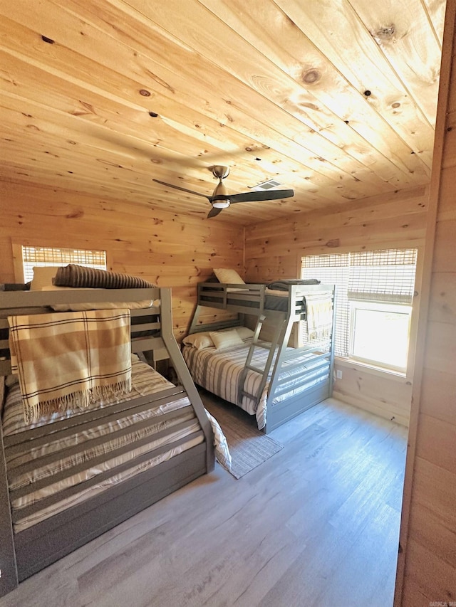 unfurnished bedroom with wood walls, wood finished floors, and wood ceiling