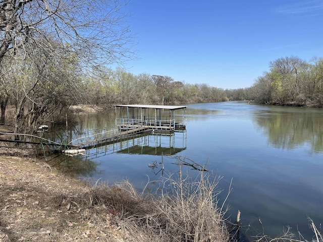 view of dock featuring a water view and a forest view