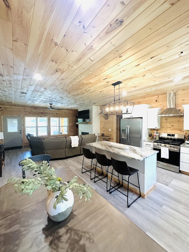 interior space featuring wood ceiling, a fireplace, light wood-style flooring, and a notable chandelier