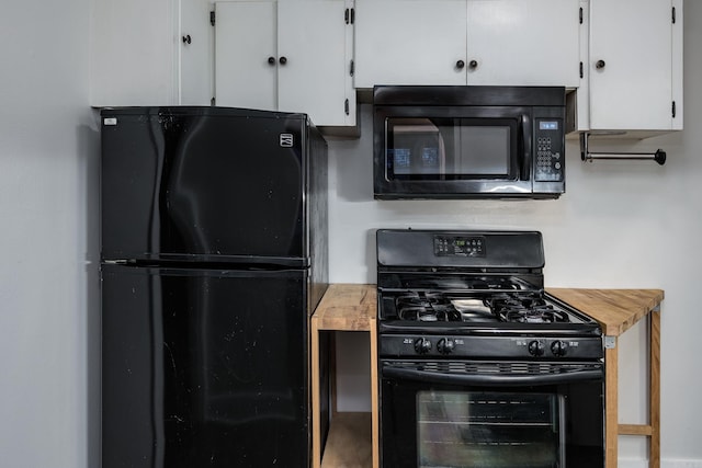 kitchen with black appliances and white cabinetry