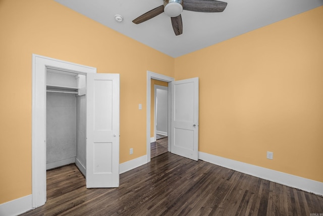 unfurnished bedroom featuring a closet, dark wood-style flooring, and baseboards