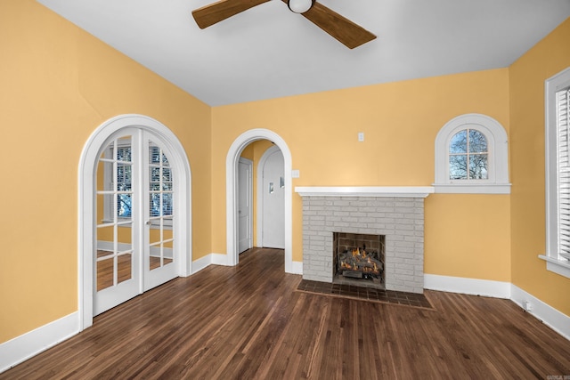 unfurnished living room featuring a fireplace, wood finished floors, and baseboards