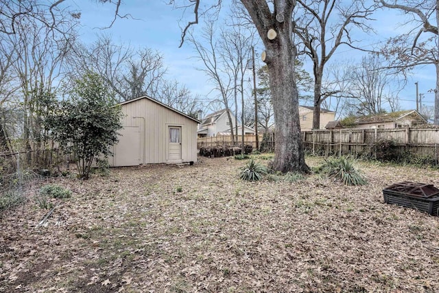 view of yard with an outbuilding, a storage shed, and a fenced backyard