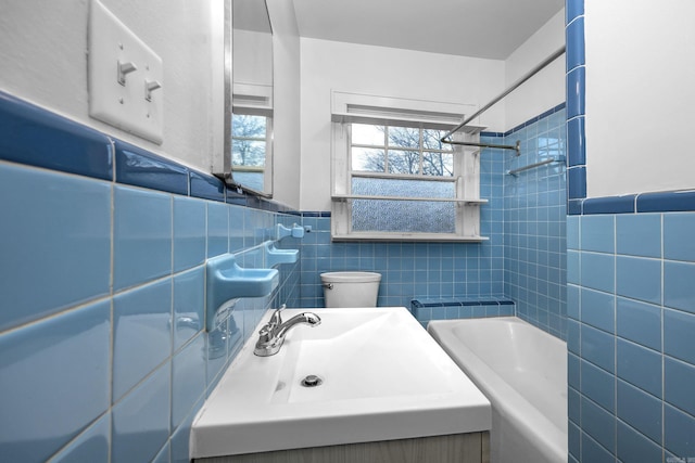 full bathroom featuring a wainscoted wall, a wealth of natural light, and tile walls