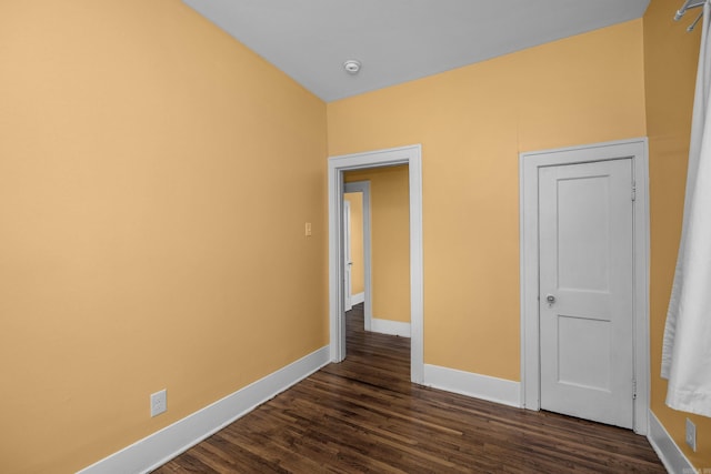 unfurnished bedroom featuring dark wood finished floors and baseboards