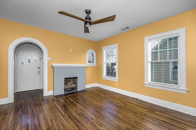 unfurnished living room featuring a fireplace, visible vents, a ceiling fan, wood finished floors, and baseboards