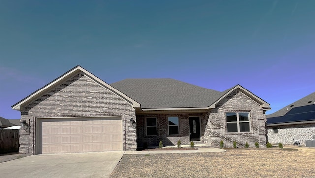 view of front of house with a garage, brick siding, driveway, and a shingled roof