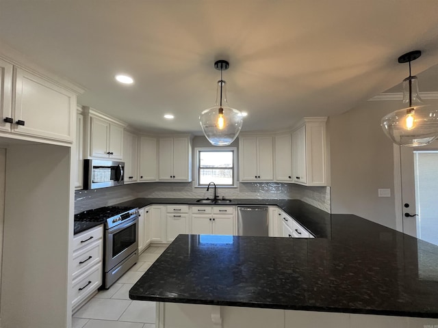 kitchen with stainless steel appliances, tasteful backsplash, light tile patterned flooring, a sink, and white cabinetry