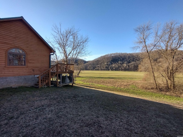 view of yard featuring a deck with mountain view and stairs