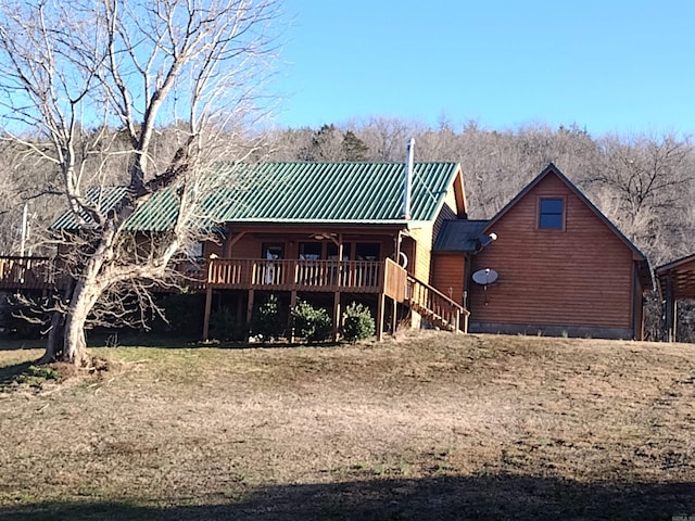 back of property featuring stairs, a deck, and metal roof