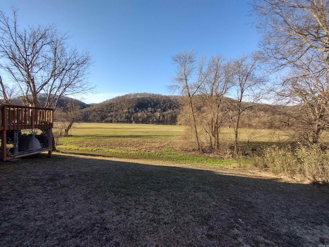 view of yard with a deck with mountain view