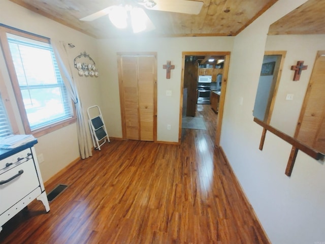 interior space with ceiling fan, wood finished floors, visible vents, and baseboards