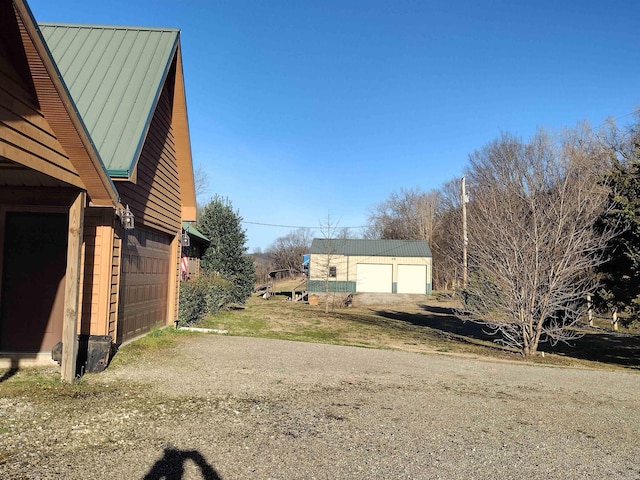 view of property exterior featuring a garage and metal roof