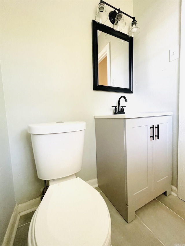 half bath with tile patterned flooring, vanity, toilet, and baseboards