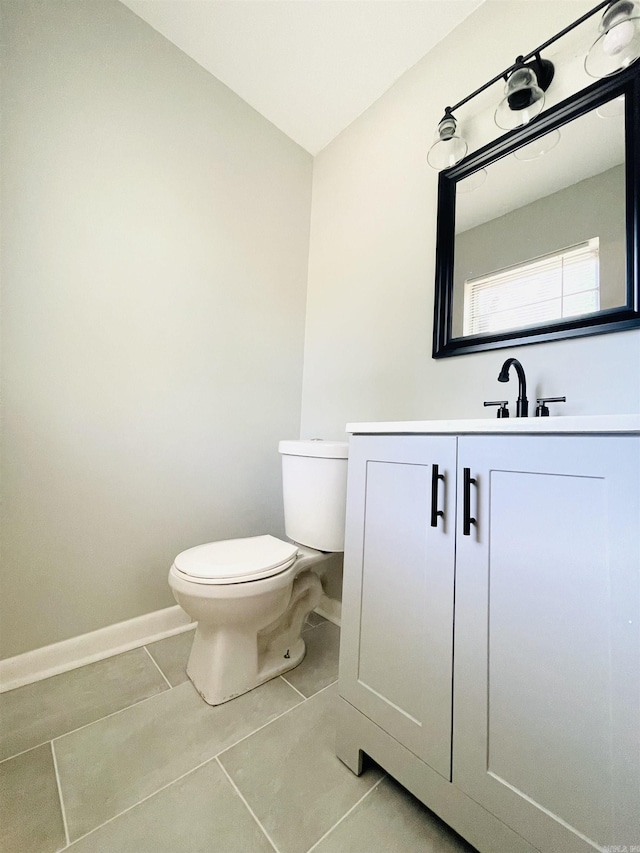 bathroom featuring tile patterned flooring, vanity, toilet, and baseboards