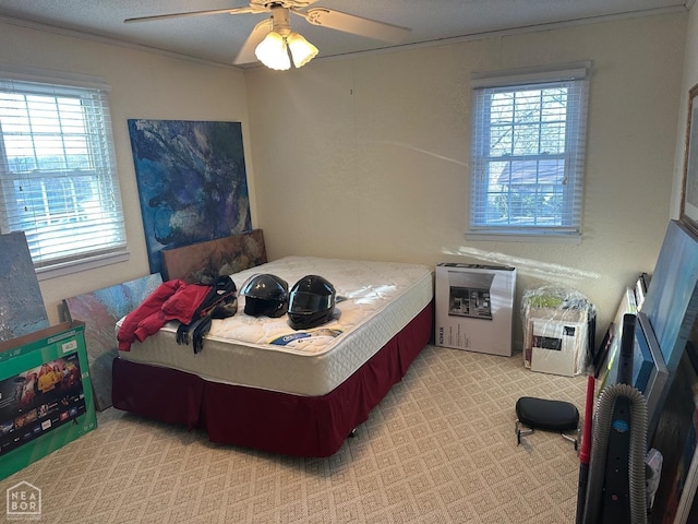 bedroom featuring carpet floors, multiple windows, ornamental molding, and a ceiling fan